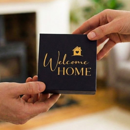 Hands exchanging a "Welcome HOME" gift box.